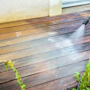 Dilunett being washed off a deck with a pressure washer
