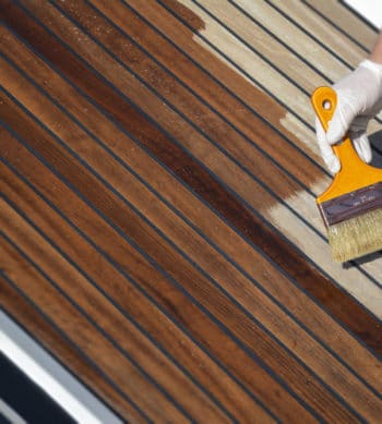 Deks Olje D1 being applied to a boat deck with a brush