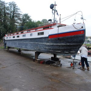 Narrow boat in a dry dock being blackened