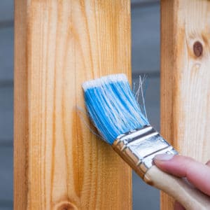 Person brushing wooden plank