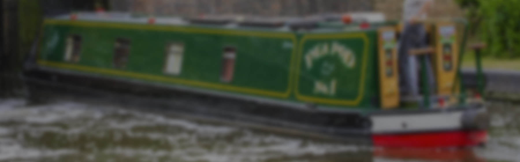 A man cruising on his green narrowboat