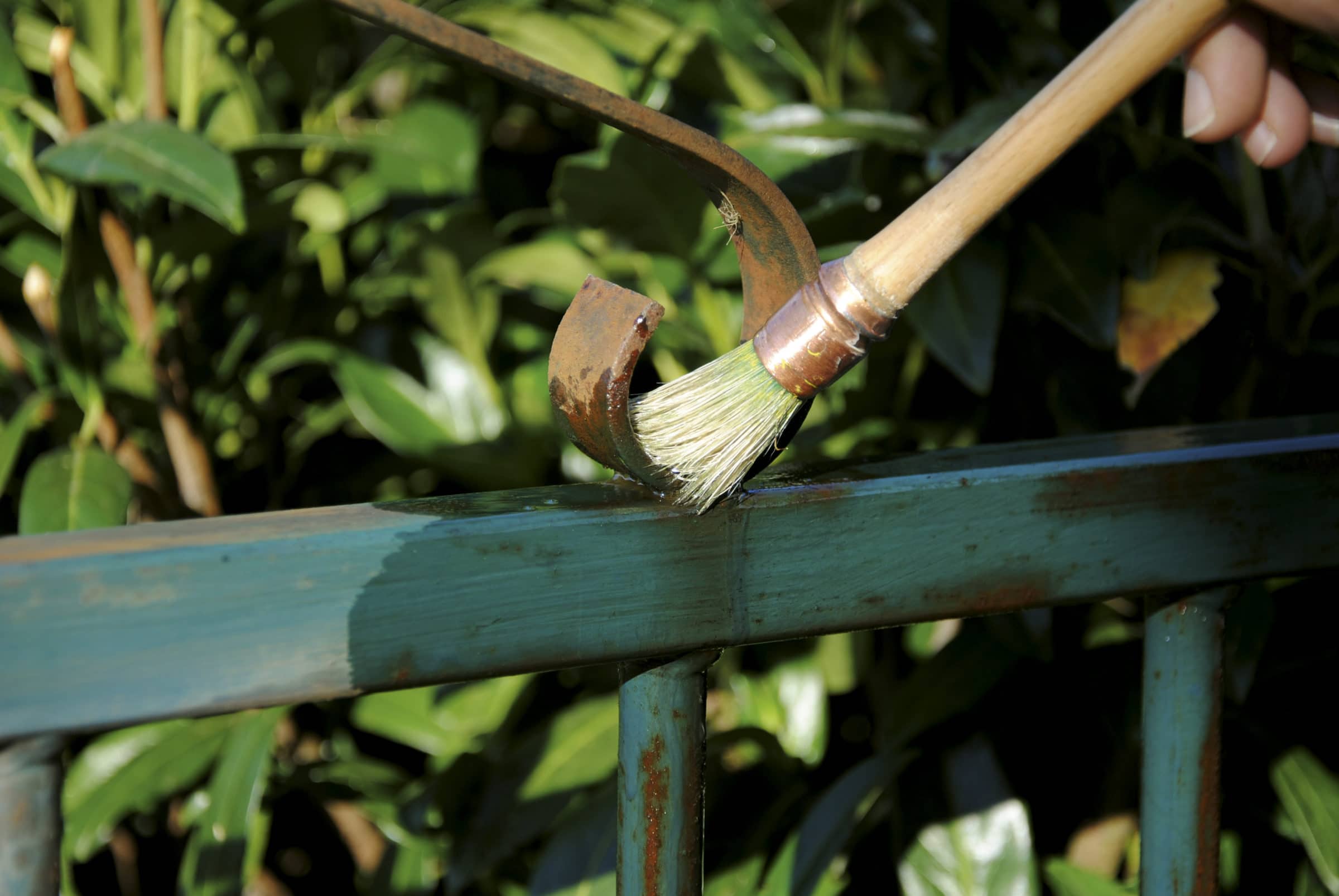 Owatrol Oil being applied to a rusted metal fence