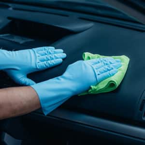 Person wiping down car dashboard